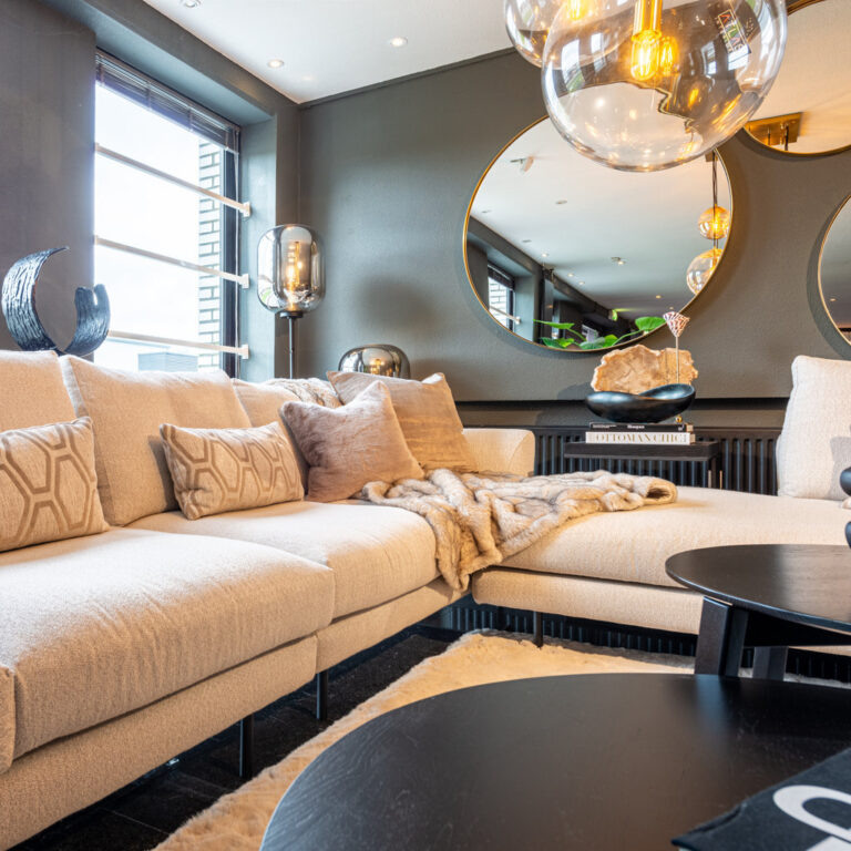 Showroom van Atlas Interiors in Capelle aan den IJssel met lichte loungebank en spiegel